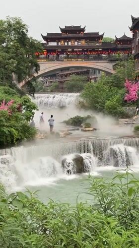 Scenic waterfall and traditional townscape captured in Furong, China