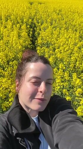 Woman films selfie videos in German flower field