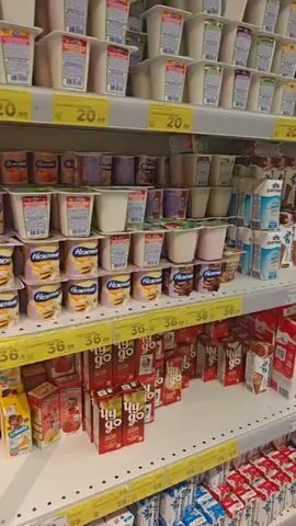 The video shows shelves in a grocery store stocked with dairy products. The shelves are filled with various brands and types of milk, yogurt, and other dairy beverages in cartons and plastic containers. Prices are visible on some of the shelves. The products are neatly arranged, and the lighting suggests an indoor retail environment. There are no people visible in the video.