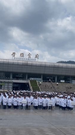 White-coated group gathers outside Chongqing canteen building