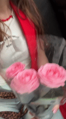 Woman holds pink roses in car in Kryvyi Rih
