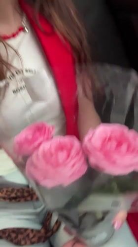 Woman holds pink roses in car in Kryvyi Rih