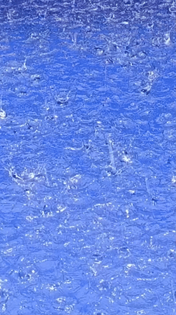 Rain Creates Ripples on Blue Pool Surface
