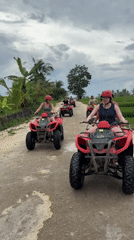 Red-helmeted riders on numbered ATVs traverse Payangan dirt roads