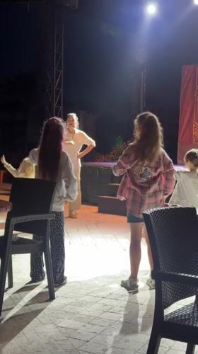 Dance instructor teaches four girls on illuminated stage in Turkey