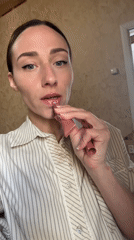 Woman applies lip gloss in Saint Petersburg bathroom