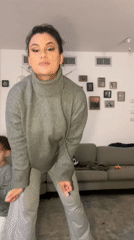 Woman dances in living room while family watches