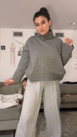 Woman dances in living room while family watches