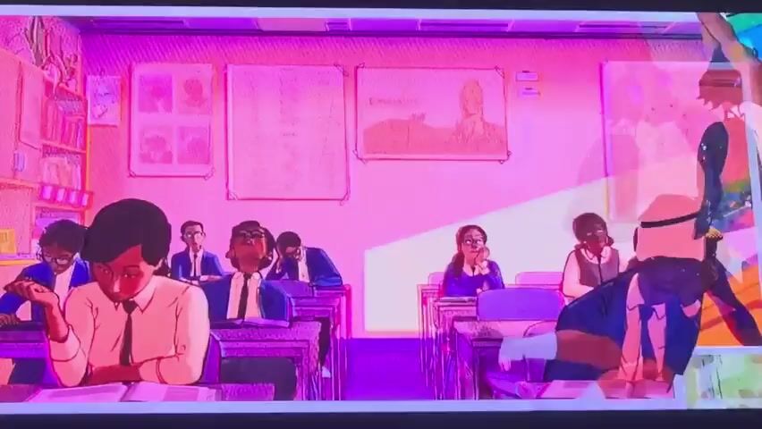 The video displays scenes from an animated production with a vibrant, almost surreal color palette, dominated by pinks and purples.

The first scene depicts a classroom setting where several young individuals, dressed in school uniforms, are seated at desks. One person in the foreground is looking down, appearing thoughtful or bored, while another student in the background has their arm raised, actively participating or seeking attention. The classroom walls are adorned with educational posters.

The second scene shifts to an action sequence, showing a figure in a superhero-like costume engaged in combat with a grotesque, masked antagonist. The visual style here is dynamic and energetic, characteristic of comic book adaptations.

The third scene shows a character, again in a dynamic pose, suspended upside down above a group of dogs in what appears to be an outdoor market or street. The setting is filled with stalls and structures, suggesting an urban environment, possibly in a warmer climate given the open-air nature. The overall mood varies from the quiet focus of a classroom to the intensity of a fight and the playful chaos of the final scene.

There is no discernible text visible in the provided frames, nor are there specific cues about the time of day or weather conditions beyond the artificial lighting that creates the distinct color scheme. The location context of Vozrozhdeniye, Russia, is not visually indicated within the frames themselves. The emotions conveyed range from boredom and engagement in the classroom to action and potential humor in the subsequent scenes.