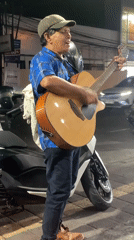 Acoustic guitar session on a Denpasar sidewalk at night