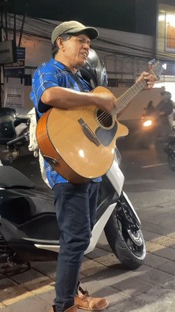 Acoustic guitar session on a Denpasar sidewalk at night