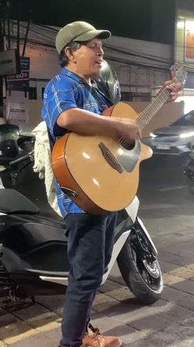 Acoustic guitar session on a Denpasar sidewalk at night
