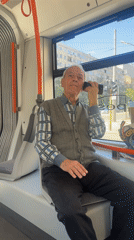 Elderly man makes phone call on Sofia tram