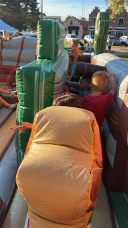 Kids tackle a western-themed inflatable obstacle course outdoors