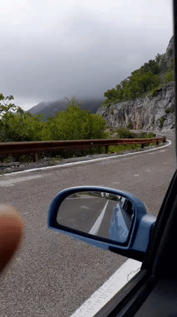 Vehicle travels winding mountain road in Brda, Montenegro