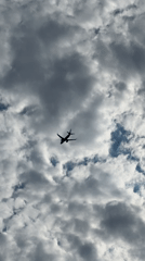 Plane silhouette crossing a dramatic cloudy sky over Dieppe