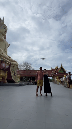 Tourists visit golden Buddha temple in coastal Thai fishing village