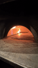 Wood-fired pizza cooking in a stone oven, West Palm Beach