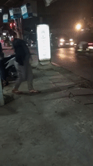 Night traffic and street life along a roadside sign in Setu
