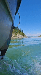 Boat travels through green waters near Kruševica, Montenegro
