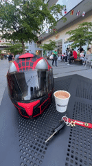 Coffee and helmet on a table outside a Maracay shopping strip