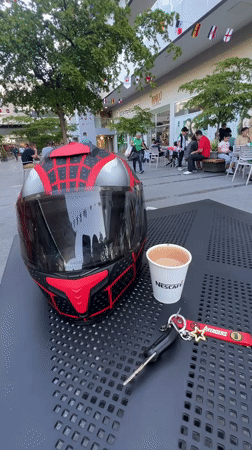 Coffee and helmet on a table outside a Maracay shopping strip