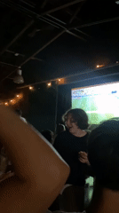 Crowd gathers in dark room to watch soccer on big screen
