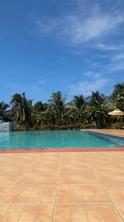 Woman enjoys poolside beverage in Vietnam early morning