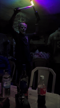 Person in clown mask performs with light bars in Nigeria