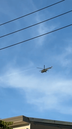 Helicopter passes over Đà Nẵng skyline through power lines