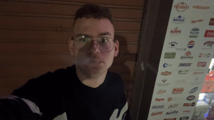 Man smoking outside closed business in Plovdiv evening