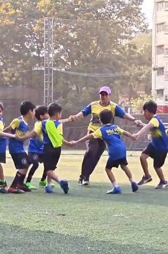 Children play soccer and rollerblade at Mumbai school playground