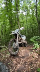 Muddy dirt bike parked in Bulgarian forest