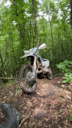 Muddy dirt bike parked in Bulgarian forest