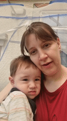 Woman takes playful selfie with baby under netting structure