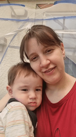 Woman takes playful selfie with baby under netting structure