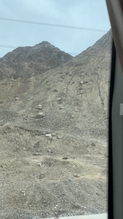 Vehicle travels through rocky mountain landscape in Guazhou County