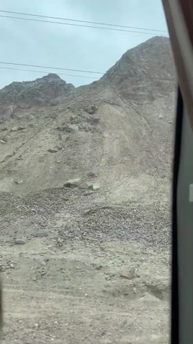 Vehicle travels through rocky mountain landscape in Guazhou County