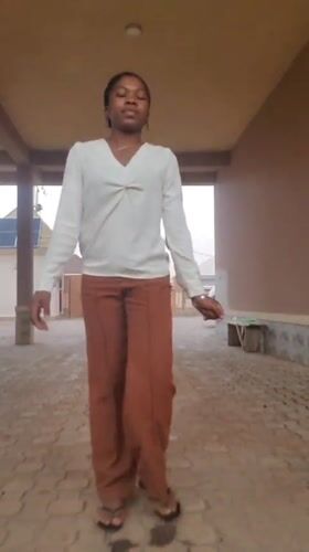 Woman creates selfie content in covered walkway, Nigeria