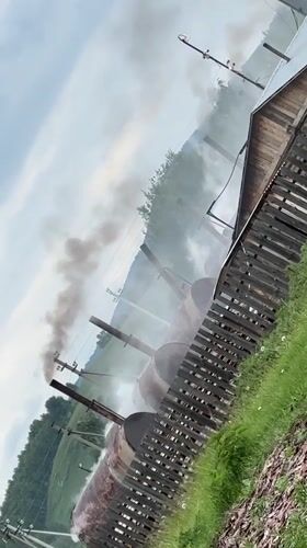 Rural Russian village shows industrial smoke amid pastoral scenes