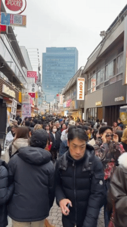 Winter crowds fill narrow Shibuya street during morning hours