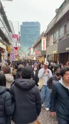Winter crowds fill narrow Shibuya street during morning hours