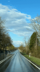 Wet road reflects sky in Junglinster, Luxembourg