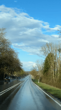 Wet road reflects sky in Junglinster, Luxembourg