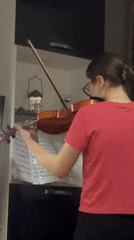 Violin practice session captured in Tbilisi apartment during sunset