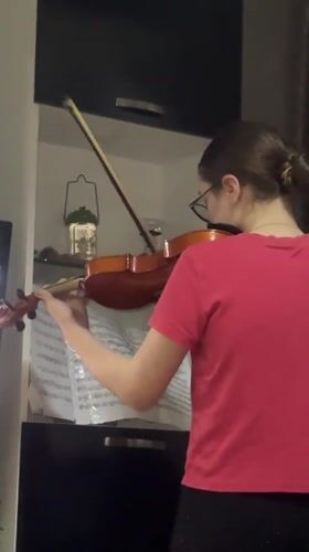 Violin practice session captured in Tbilisi apartment during sunset
