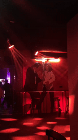 Red-lit bar interior with dance mural observed in Saratov