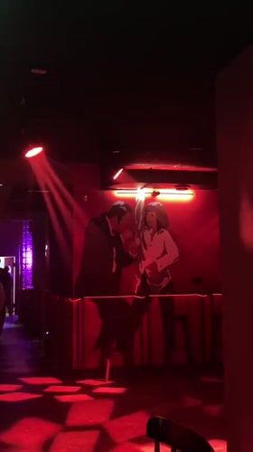 Red-lit bar interior with dance mural observed in Saratov