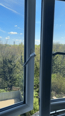 Window opened revealing London green space and skyline view