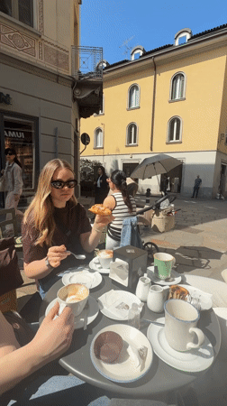 Women enjoy morning pastries at outdoor cafe in Lecco